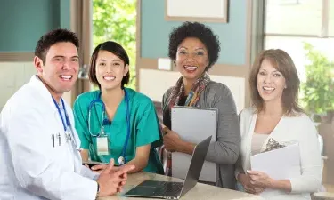 Public Health Nurse with Healthcare Team Smiling in Clinic